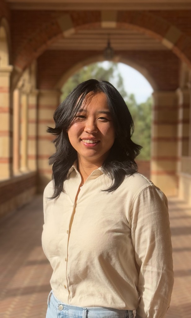 Portrait of Caitlin Tang standing in an arched hallway